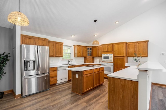 kitchen with pendant lighting, sink, white appliances, and dark wood-type flooring