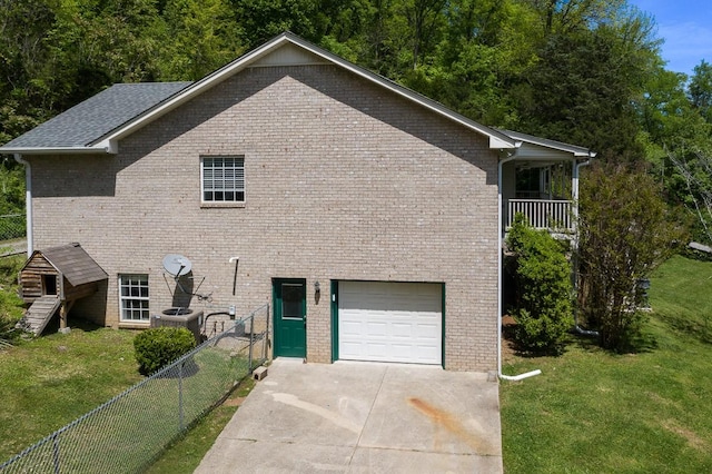 view of home's exterior with a balcony, a garage, a yard, and central AC unit