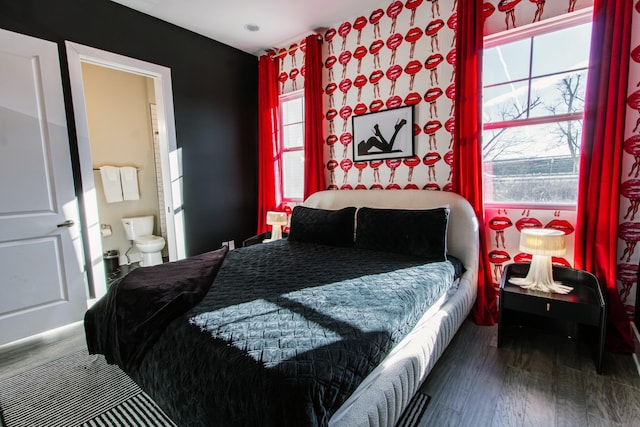 bedroom with hardwood / wood-style floors and ensuite bathroom