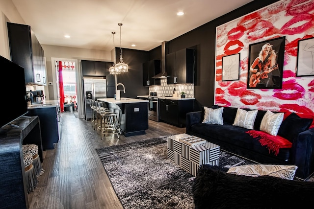 living room with dark hardwood / wood-style flooring, sink, and a notable chandelier