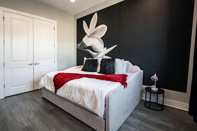 bedroom with dark hardwood / wood-style flooring and a closet