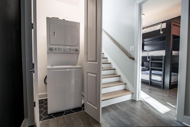 laundry room featuring dark hardwood / wood-style floors and stacked washer and clothes dryer