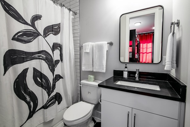 bathroom with walk in shower, vanity, and toilet