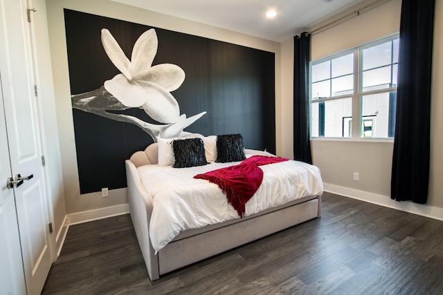 bedroom with dark hardwood / wood-style flooring and a closet