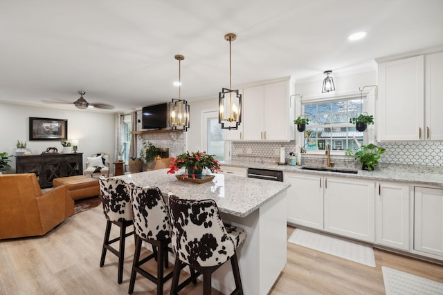 kitchen featuring sink, a kitchen breakfast bar, and white cabinets