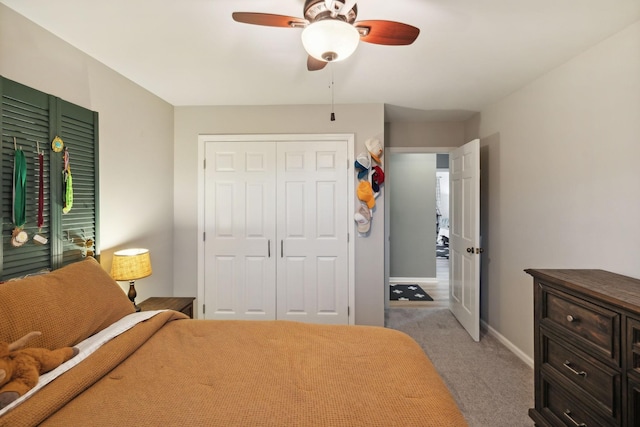 carpeted bedroom with ceiling fan and a closet