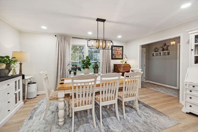 dining room featuring crown molding, light hardwood / wood-style floors, and a chandelier