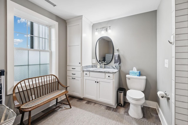 bathroom with wood-type flooring, toilet, and vanity