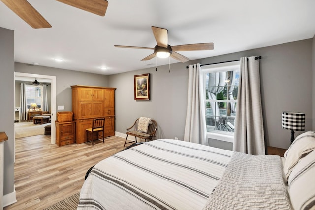 bedroom with multiple windows, ceiling fan, and light hardwood / wood-style floors