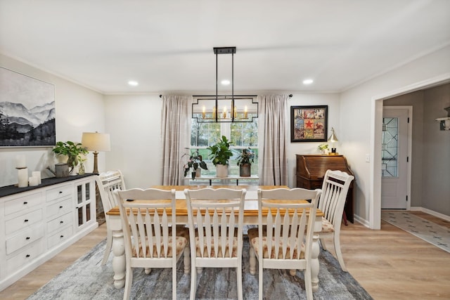 dining area featuring an inviting chandelier, ornamental molding, and light hardwood / wood-style floors