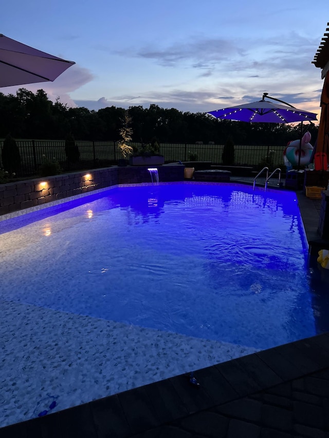 pool at dusk with pool water feature