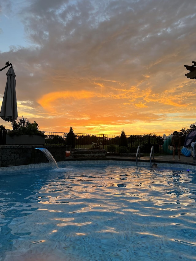 pool at dusk with pool water feature