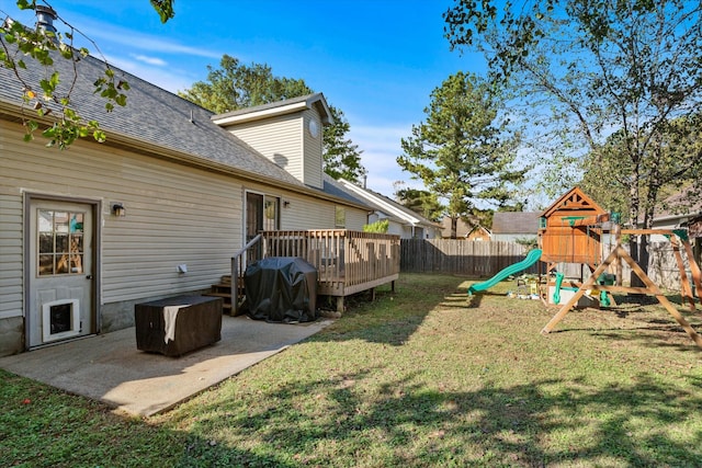 view of yard featuring a playground, a wooden deck, and a patio