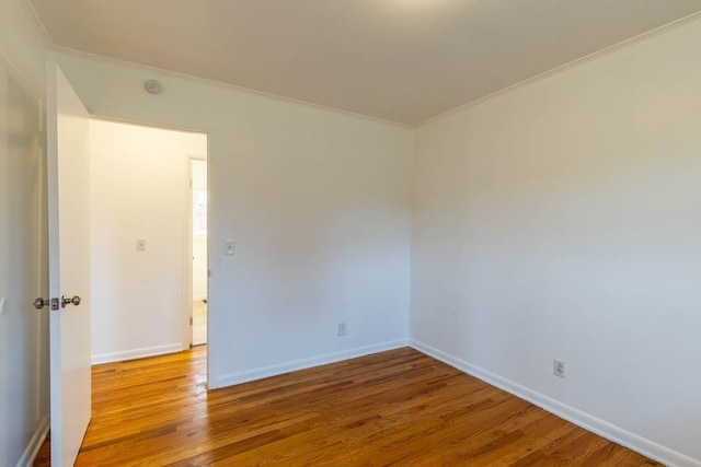 empty room with crown molding and hardwood / wood-style flooring