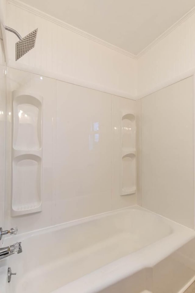 bathroom with ornamental molding and washtub / shower combination