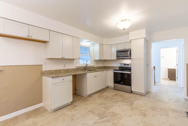 kitchen with stainless steel appliances, white cabinetry, sink, and light stone counters