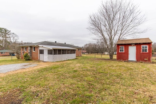 view of yard with a storage shed and a sunroom