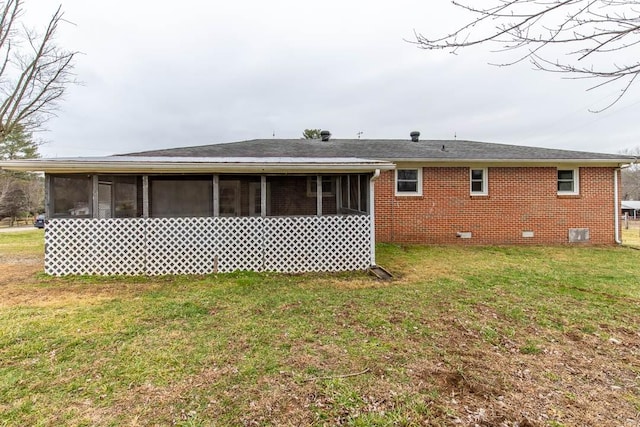 rear view of house featuring a sunroom and a lawn