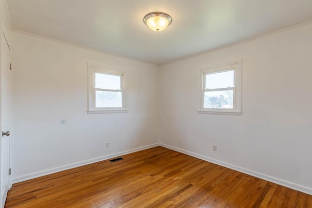 empty room featuring crown molding and wood-type flooring