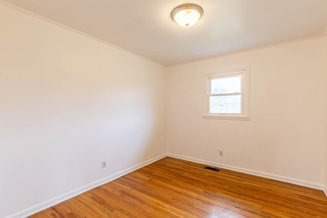 unfurnished room with ornamental molding and hardwood / wood-style floors