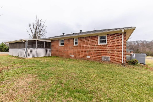 back of property with cooling unit, a yard, and a sunroom