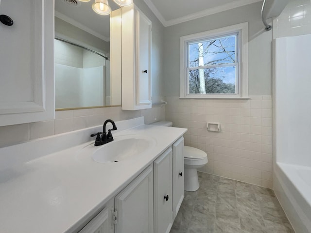 bathroom featuring crown molding, vanity, toilet, and tile walls