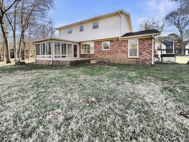 rear view of property with a lawn and a sunroom