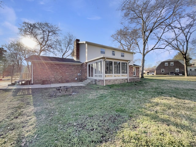 rear view of property with a sunroom and a yard