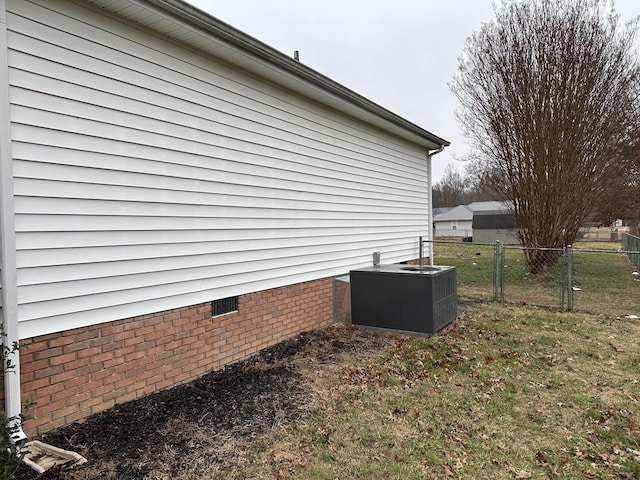 view of property exterior featuring central AC and a yard