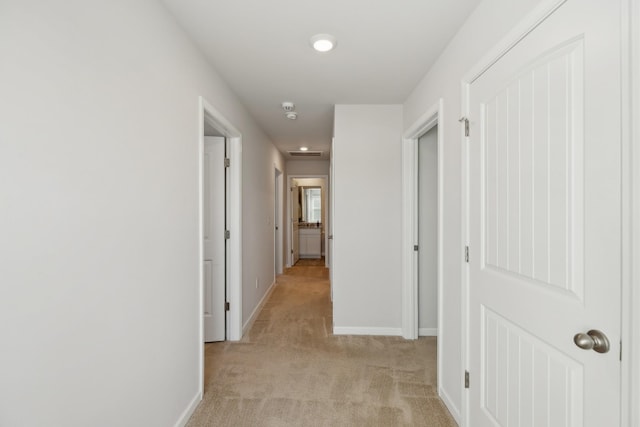 hallway featuring light colored carpet