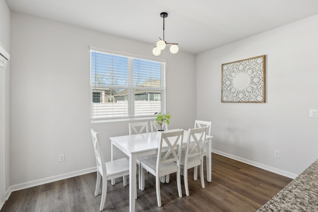 dining room with dark hardwood / wood-style flooring and a notable chandelier