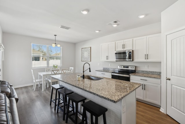 kitchen with white cabinetry, sink, pendant lighting, and stainless steel appliances