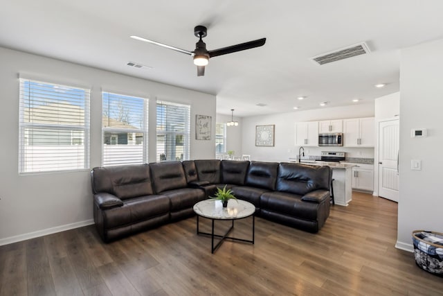 living room featuring ceiling fan, dark hardwood / wood-style floors, and sink