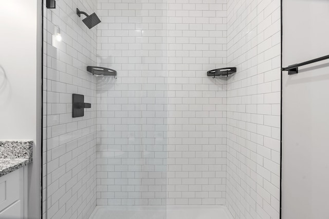 bathroom with vanity and a tile shower