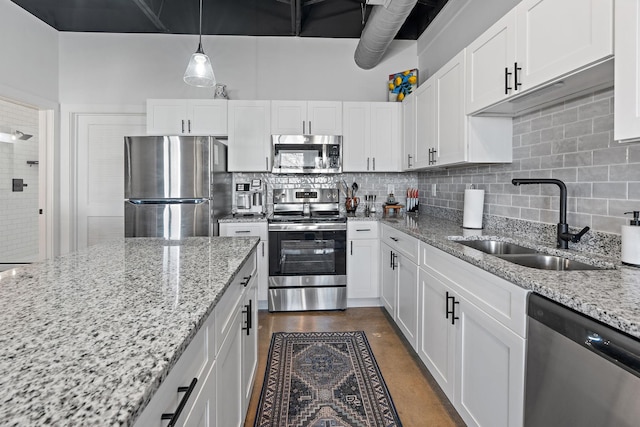 kitchen with sink, decorative light fixtures, stainless steel appliances, and white cabinets