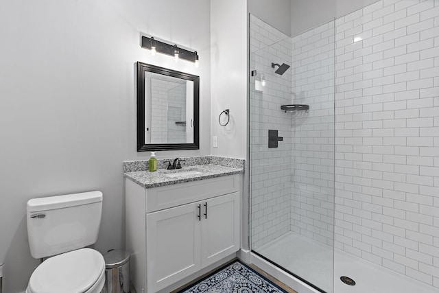 bathroom featuring tiled shower, vanity, and toilet