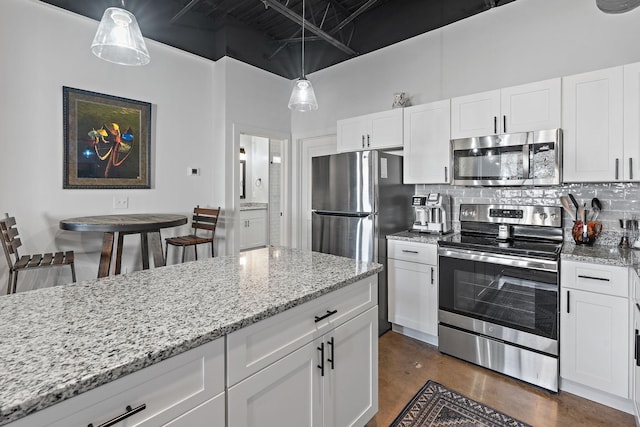 kitchen with pendant lighting, stainless steel appliances, light stone countertops, white cabinets, and decorative backsplash