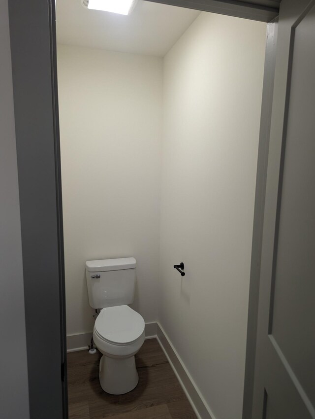 bathroom with hardwood / wood-style flooring and toilet