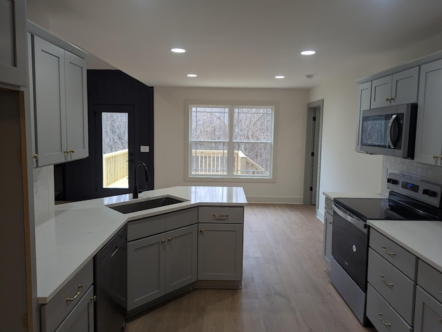 kitchen featuring gray cabinetry, sink, decorative backsplash, and appliances with stainless steel finishes