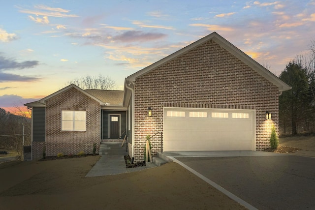 ranch-style house with brick siding, driveway, and an attached garage