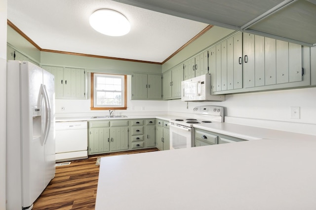 kitchen featuring sink, ornamental molding, dark hardwood / wood-style floors, kitchen peninsula, and white appliances