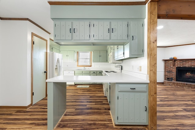 kitchen with sink, crown molding, dark hardwood / wood-style flooring, kitchen peninsula, and white appliances