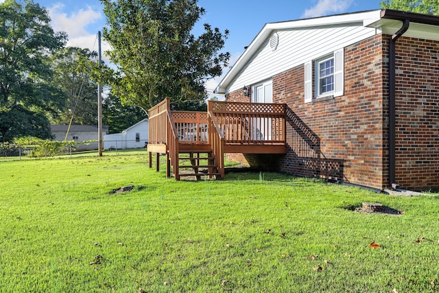 rear view of property featuring a deck and a lawn