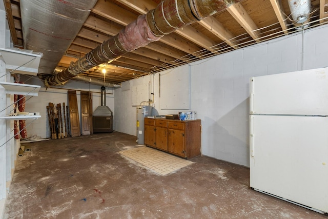 basement with electric water heater and white refrigerator