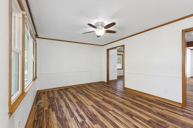 empty room featuring crown molding, dark wood-type flooring, and ceiling fan