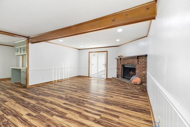 unfurnished living room with hardwood / wood-style flooring, crown molding, a fireplace, and beam ceiling