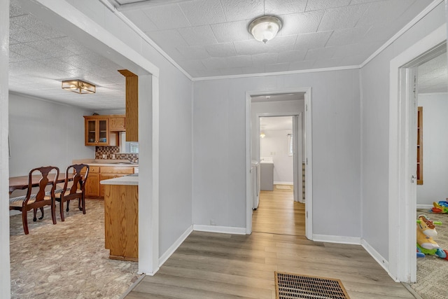 hall featuring crown molding and light hardwood / wood-style flooring