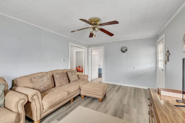 living room featuring crown molding, light hardwood / wood-style flooring, and ceiling fan