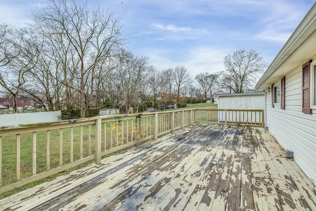 wooden terrace with a storage shed and a yard