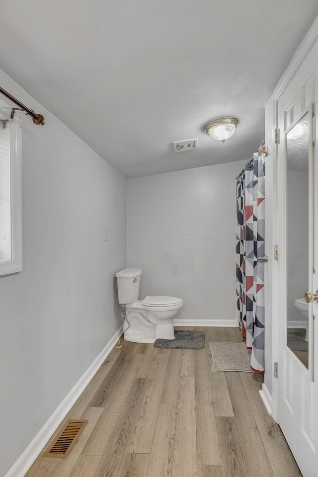 bathroom featuring wood-type flooring and toilet